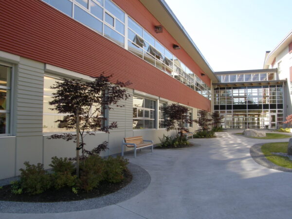 Courtyard of a modern secondary school. benches and walkways within two red and grey school buildings